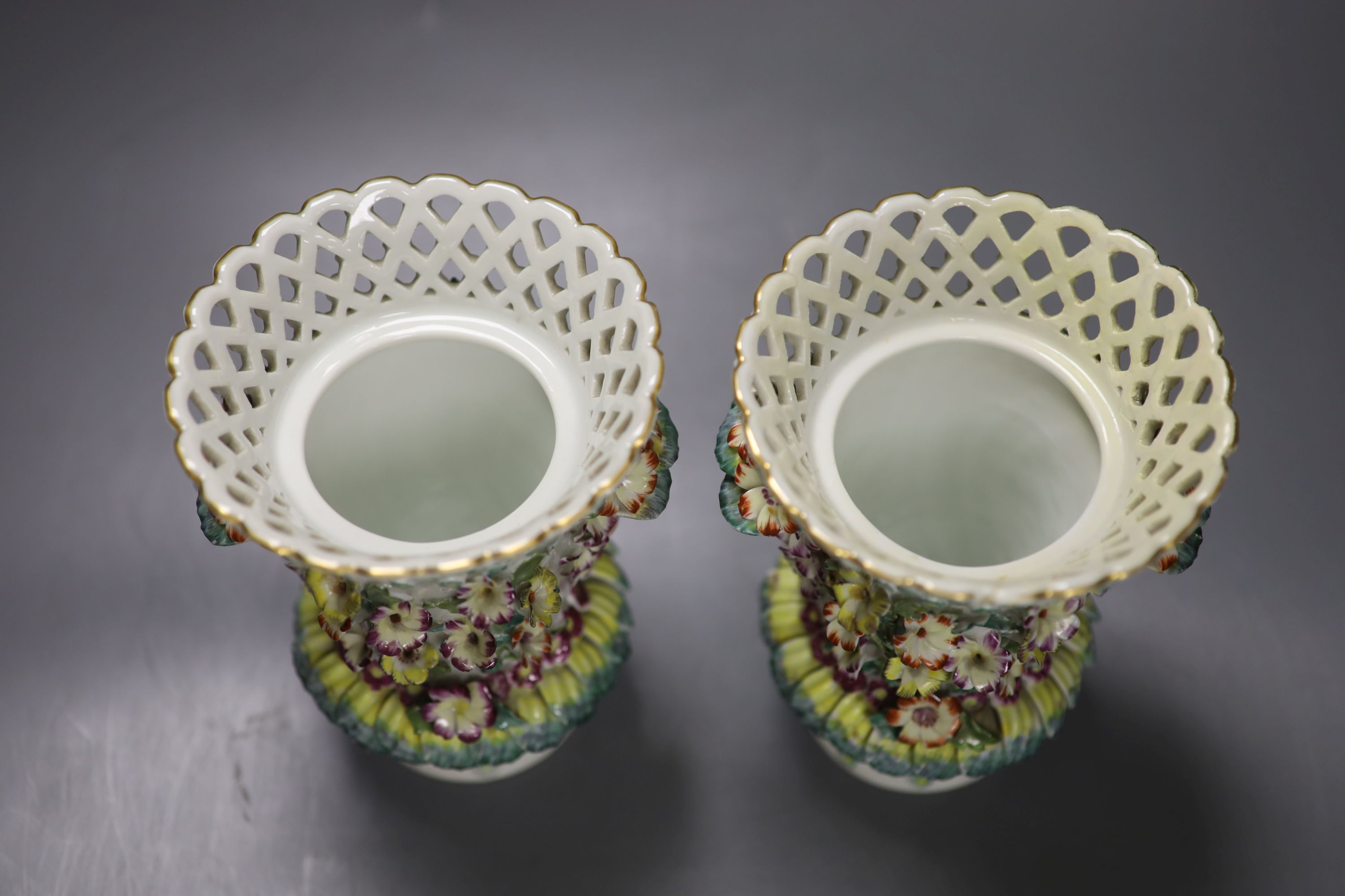 A pair of Continental frill vases with pierced necks and applied mask heads encrusted with flowers, height 18cm